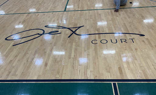 Almost in the center of the court is Allen Iverson’s signature. In the top right corner of the image, a student reaches out to touch it for luck. 