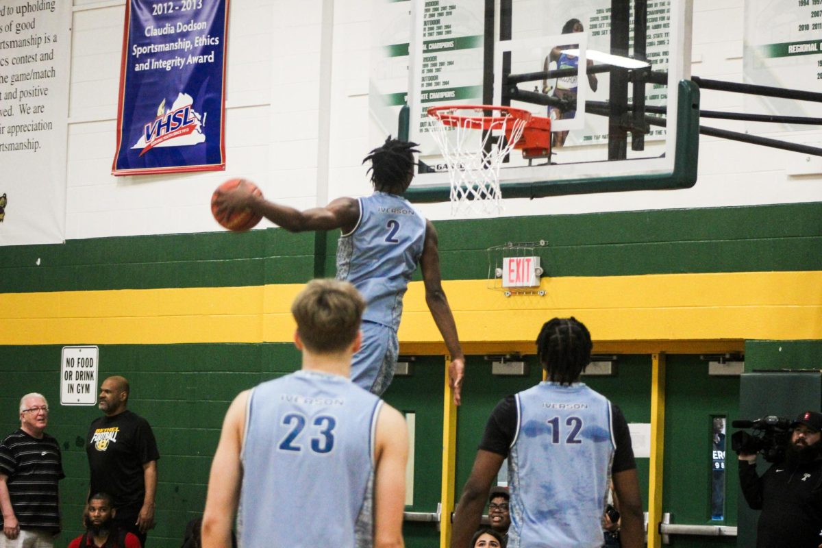 Creighton commit Larry Johnson performing a windmill dunk during warmups