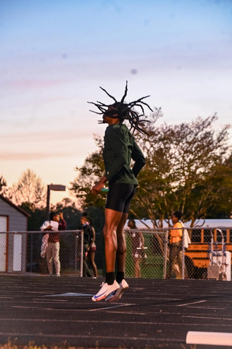 Junior KJ Harper jumping in the air before the 4x4.